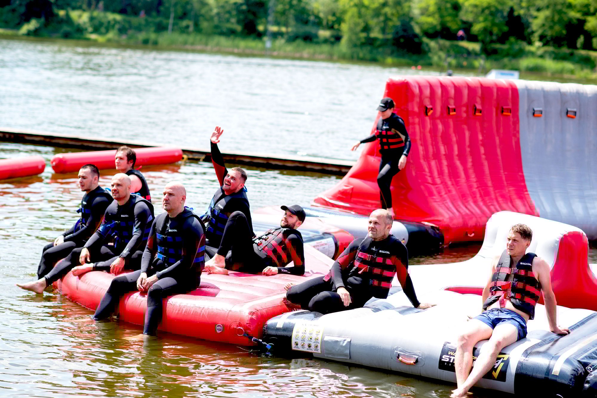 group of columbus employees in watersuits sitting on pontoons at a water attraction.