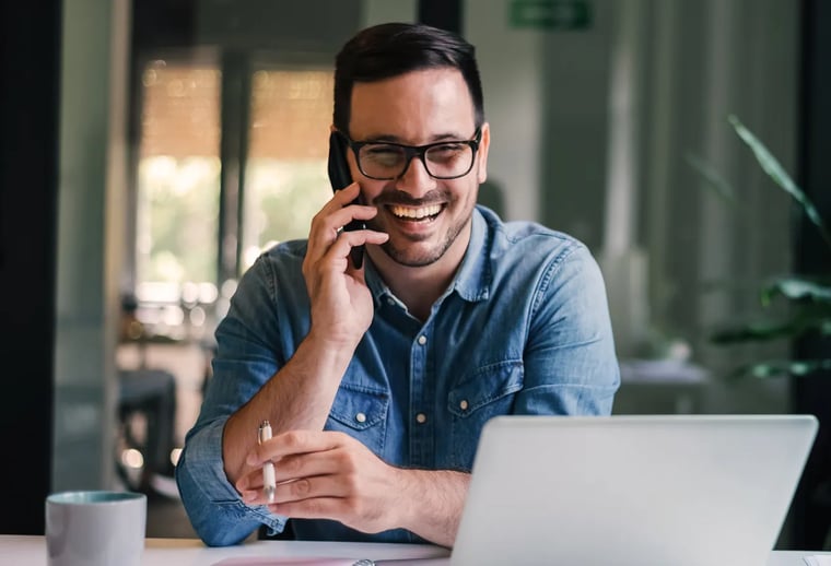 Man smiling while talking on the phone