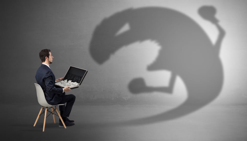 Young businessman staying and  negotiate with a monster shadow